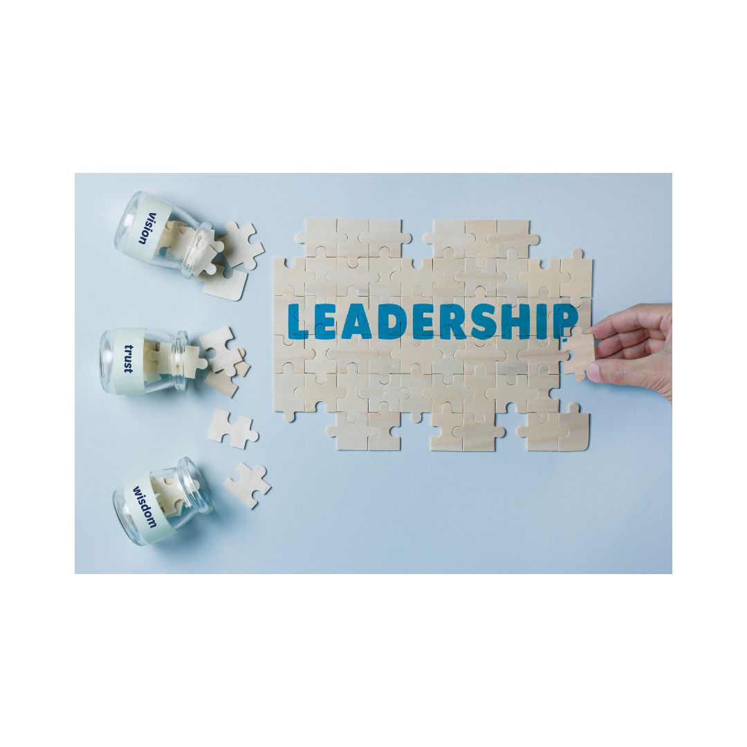 A puzzle piece with the word 'LEADERSHIP' written on it, alongside two small glass jars with a label that says 'LEADER'.