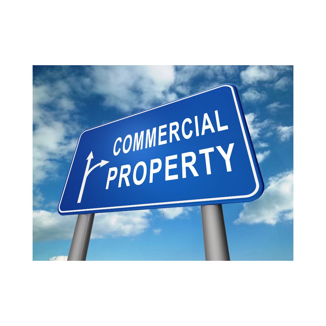 A blue sign with the text 'COMMERCIAL PROPERTY' in bold white letters, with a cloudy sky in the background.