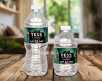 Two water bottles with personalized labels on a wooden table.