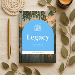 Journal titled 'Legacy' with a blue cover on a decorative surface with leaves and a candle.