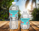 Two water bottles with personalized labels on a wooden surface with a blurred natural background